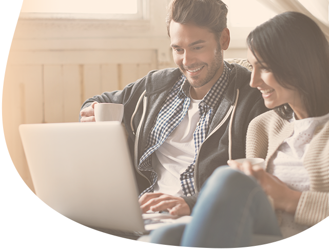 Happy couple looking at a laptop